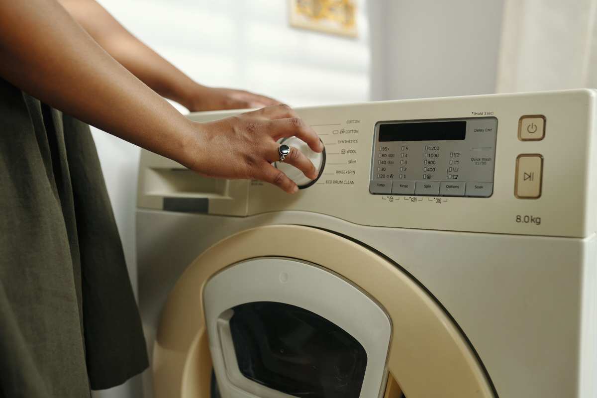 donna tocca tasti lavatrice