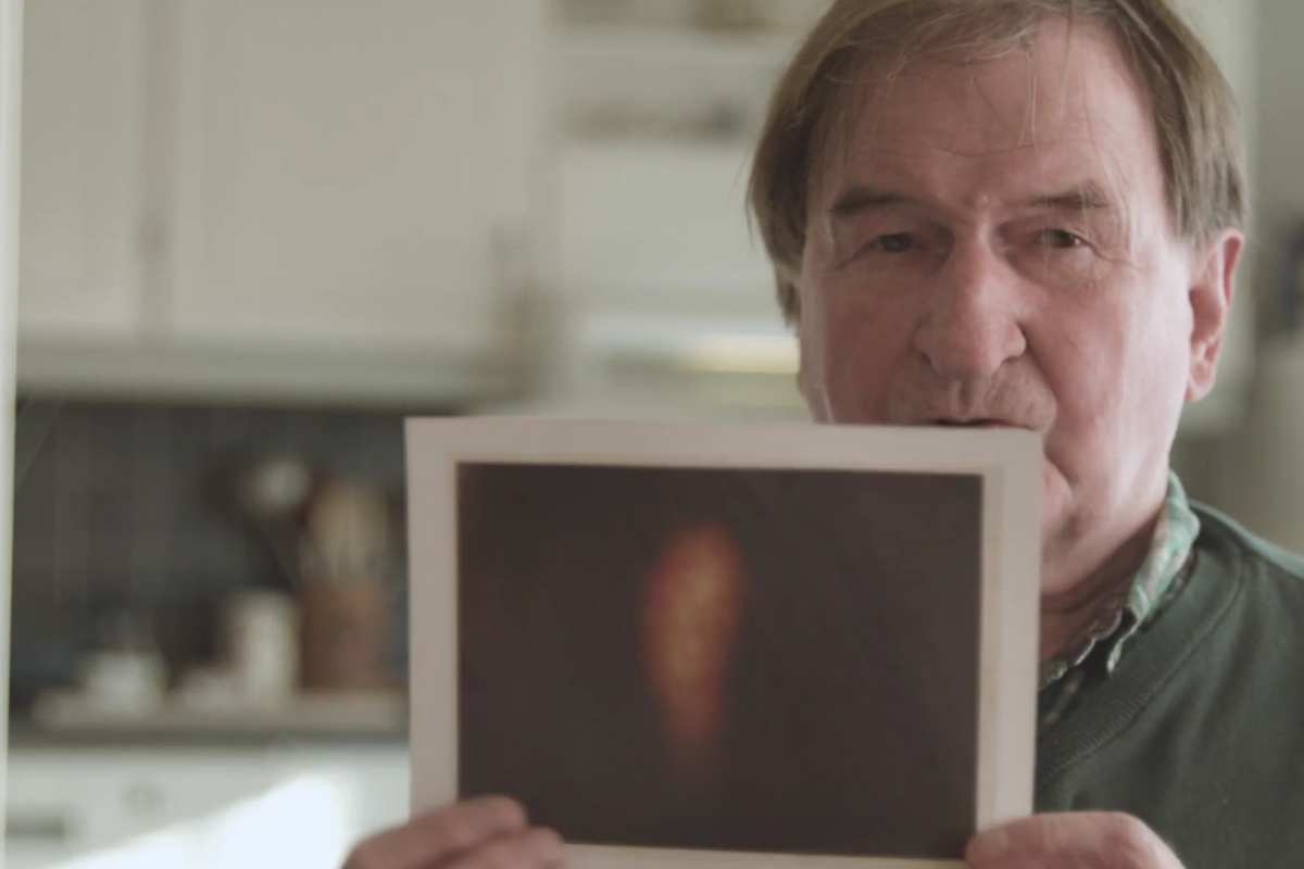 Uomo mostra le luci di Hessdalen in una foto