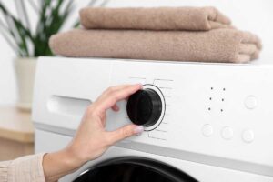 donna tocca manopola lavatrice