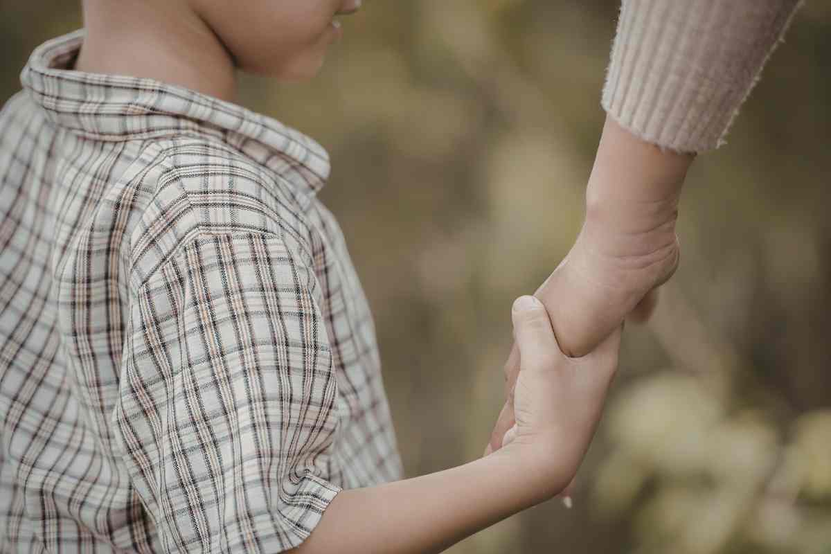 mano di bambino stringe mano di adulto