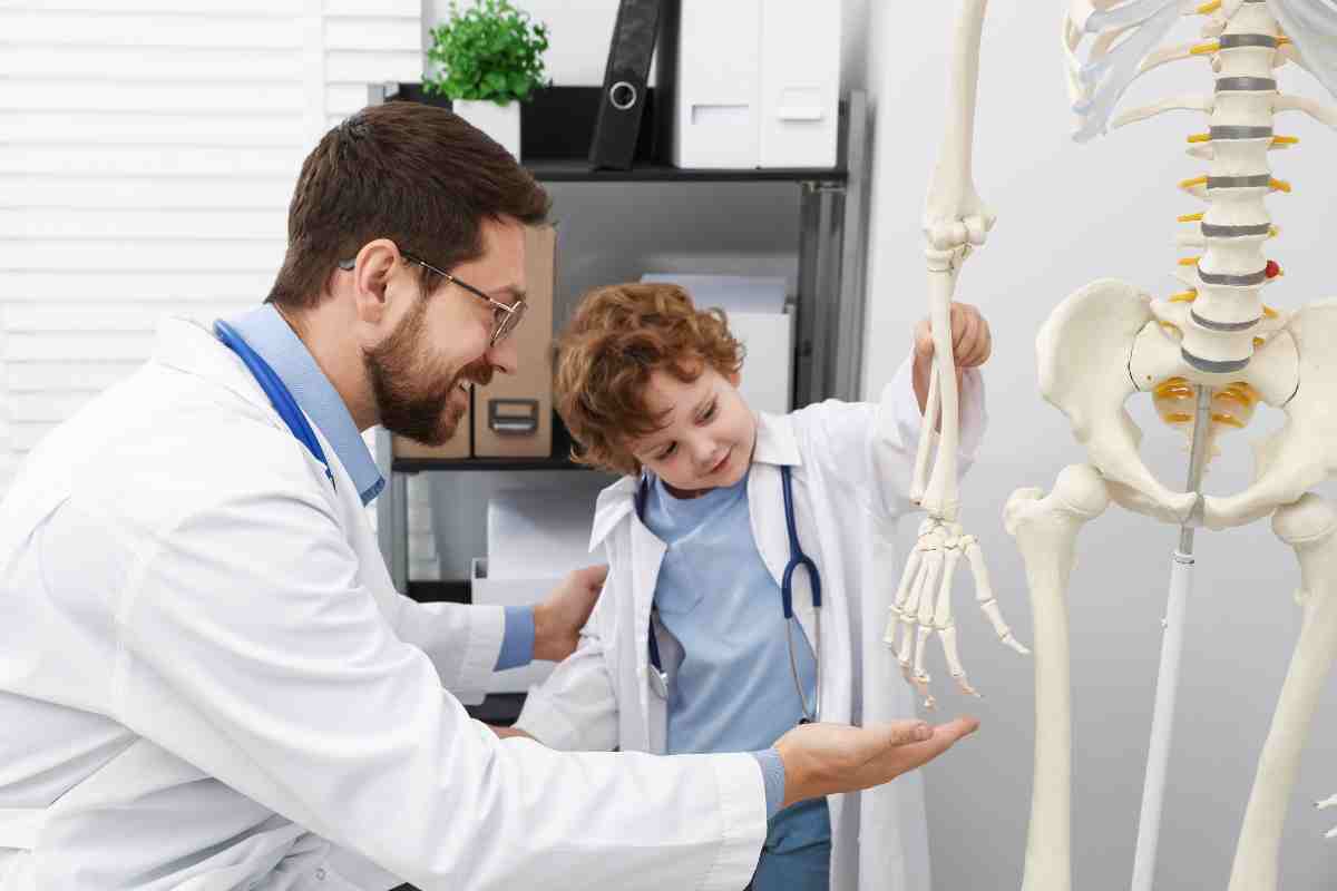 medico mostra a bambino lo scheletro di un adulto