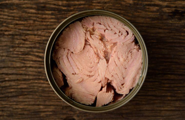 tonno in scatola appoggiato su superficie in legno