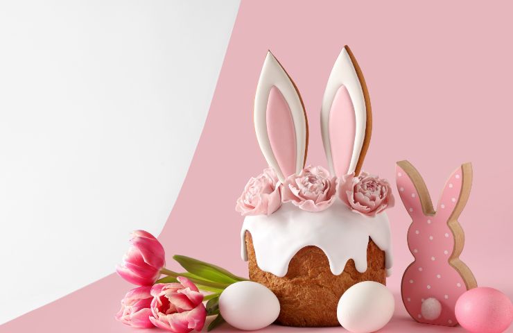 colomba, orecchie di coniglio e uova su sfondo rosa