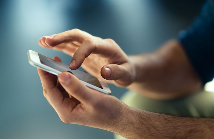 uomo con smartphone in mano